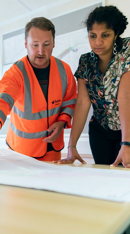 Architect and client reviewing blueprints during initial consultation