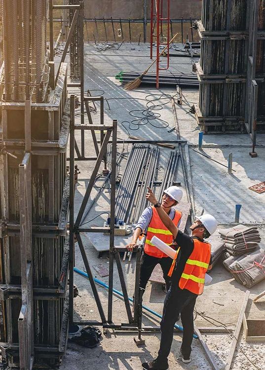 Engineers surveying site conditions and reviewing drawings on location